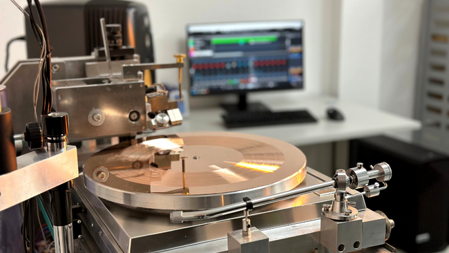 Direct metal mastering machine with copper master and software screen in the background 